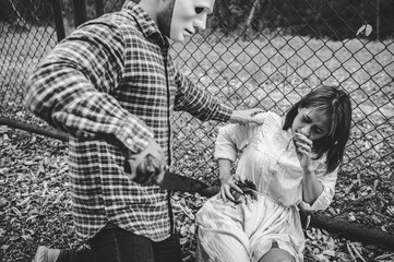 A serial killer scene is about to kill an Asian woman,concept thriller scene,Halloween festival