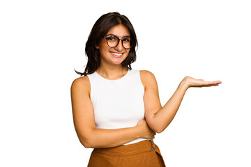 Young Indian woman isolated on green chroma background showing a copy space on a palm and holding...