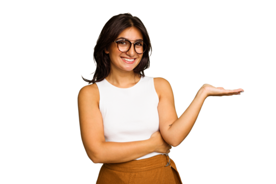 Young Indian woman isolated on green chroma background showing a copy space on a palm and holding another hand on waist.