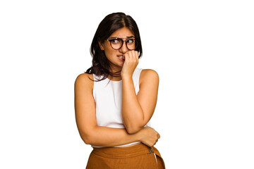 Young Indian woman isolated on green chroma background biting fingernails, nervous and very anxious.