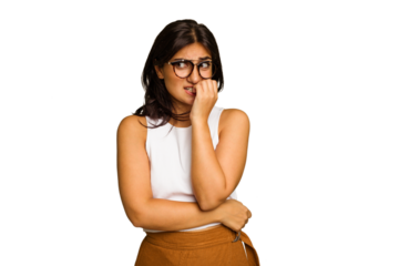 Young Indian woman isolated on green chroma background biting fingernails, nervous and very anxious.