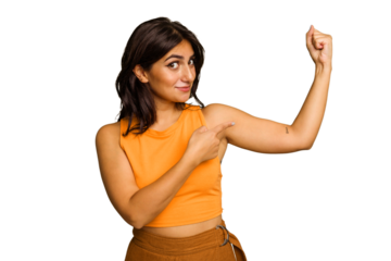 Young Indian woman isolated on green chroma background showing strength gesture with arms, symbol of feminine power