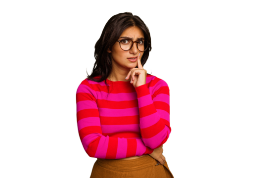Young Indian woman isolated on green chroma background looking sideways with doubtful and skeptical expression.