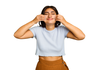 Young Indian woman isolated on green chroma background doubting between two options.