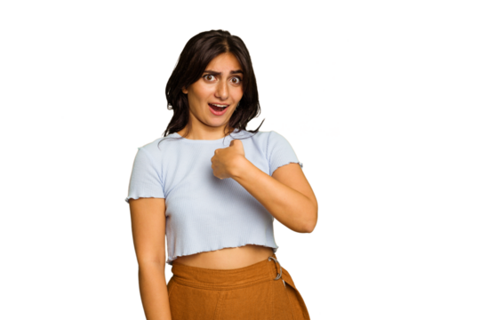 Young Indian woman isolated on green chroma background surprised pointing with finger, smiling broadly.