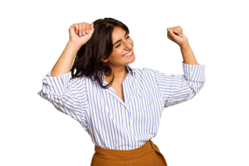 Young Indian woman isolated on green chroma background celebrating a special day, jumps and raise arms with energy.