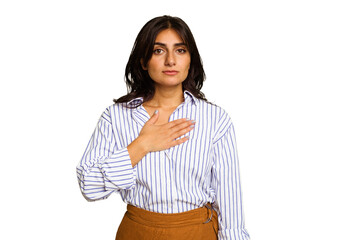 Young Indian woman isolated on green chroma background taking an oath, putting hand on chest.