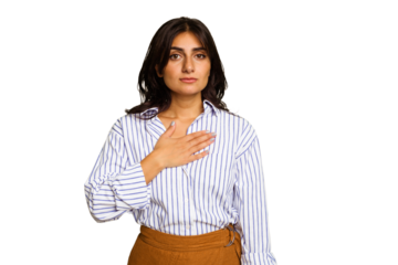 Young Indian woman isolated on green chroma background taking an oath, putting hand on chest.