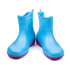 Wet blue rubber boots for gardening, isolated on white background