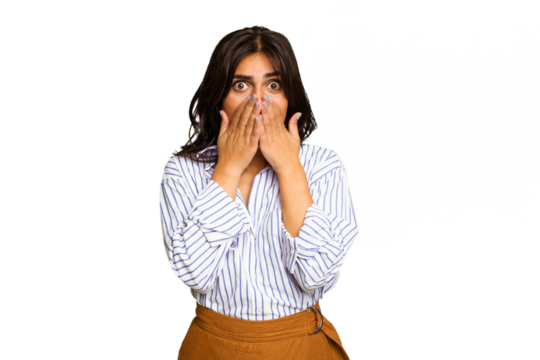 Young Indian woman isolated on green chroma background shocked, covering mouth with hands, anxious to discover something new.