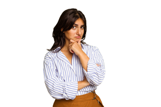 Young Indian woman isolated on green chroma background thinking and looking up, being reflective, contemplating, having a fantasy.