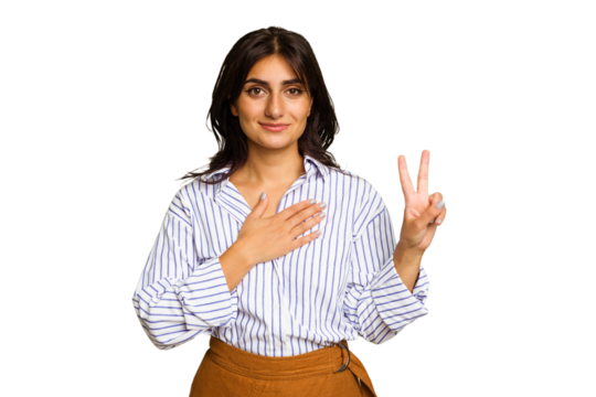 Young Indian woman isolated on green chroma background taking an oath, putting hand on chest.