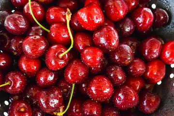 Red cherries with drops of water in a bowl in summer