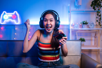 Young asian woman is using virtual reality headset. Neon light studio portrait. Concept of virtual reality, simulation, gaming and future technology.Asian woman play game in living room.