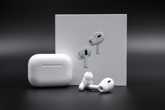 Apple AirPods Pro 2nd generation next to charging case and packaging box on black background, October 2, 2022, Germany