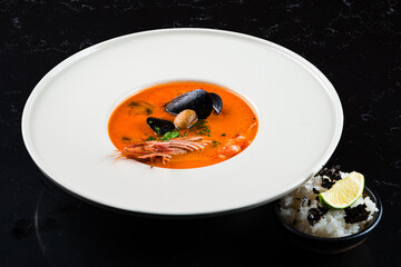 Tom Yam kung Spicy Thai soup with shrimp, seafood, coconut milk and chili pepper