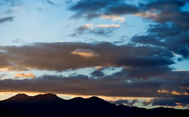Naklejka na ściany i meble Beautiful sunset sky with clouds in mountains