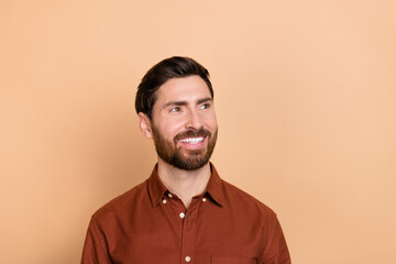 Obraz premium Portrait of satisfied nice young man toothy smile look interested empty space isolated on beige color background