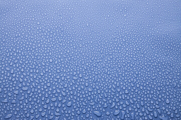 Obraz premium Tiny water droplets on light violet or very peri background as dew or spray pattern with gradient color, top view.