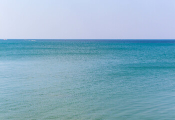 The sea is blue to the horizon during the summer day