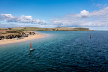 Old fashioned sailboat with red sail on the Camel Estuary