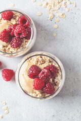 Overnight oatmeal with raspberries, currants and tahini in jars. Breakfast concept.