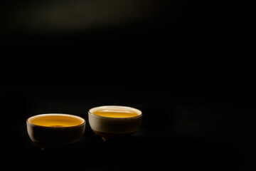 Traditional japanese, chinese asian tea ceremony concept. White ceramic tea cups with lotus on black background. Copy space.
