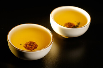 Traditional japanese, chinese asian tea ceremony concept. White ceramic tea cups with lotus on black background. Copy space.
