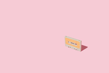 Audio cassette. A symbol of the eighties of the last century. On a pastel pink background. Creative...
