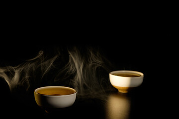 Two cups of chinese tea  with steam isolated on black background. Top view