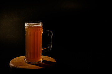 Мug of beer isolated on black background. Space for text