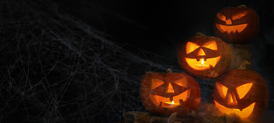 Scary Halloween celebration holiday background banner panorama - Spooky carved pumpkins and dust in the dark black night