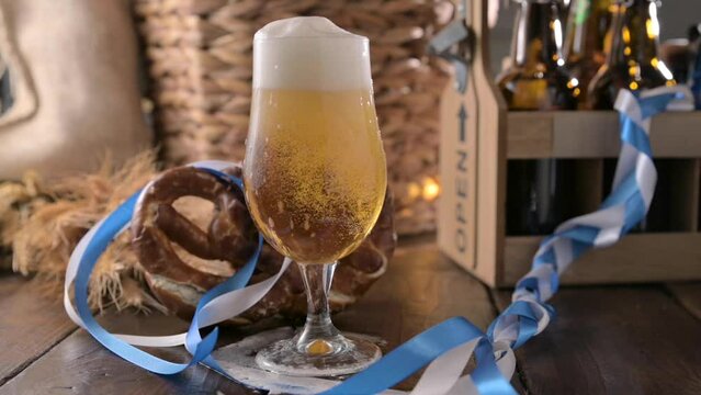 Oktoberfest beer. Foamy beer is poured into a glass and the decor of the oktober fest in germany. And Bretzel - tradition Bavarian snack. High quality FullHD footage