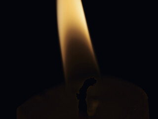 Macro photo of a lit candle flame on a dark background