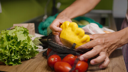 Obraz na płótnie Canvas Woman takes fresh squash out of mesh bag with vegetables