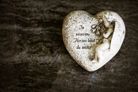 Herz auf Grab mit Schrift "In unseren Herzen lebst du weiter"