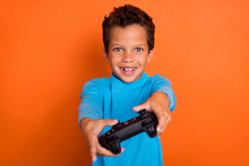 Close up photo of overjoyed boy have fun free time hobby dressed stylish blue pullover isolated on orange color background