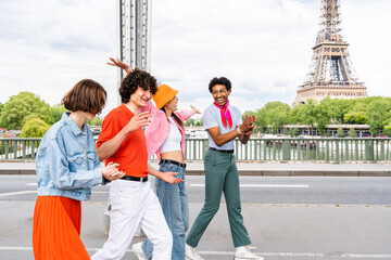 Multiethnic group of young happy teens friends bonding and having fun while visiting Eiffel Tower area in Paris, France