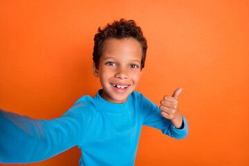 Photo portrait of adorable little boy video call show thumb up good job feedback wear trendy blue...