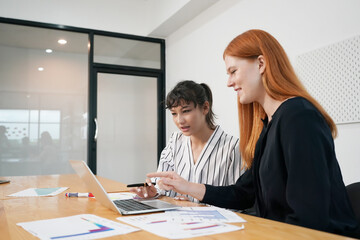 Two business people working together on laptop.