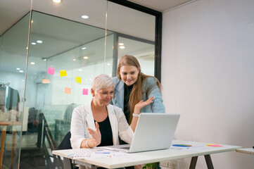 Two business people working together on laptop.