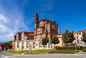 Fototapeta na wymiar Fossano, Cuneo, Piedmont, Italy - October 03, 2022: The church of the Holy Trinity or Battuti Rossi (beaten reds) with the hospital building of the holy trinity