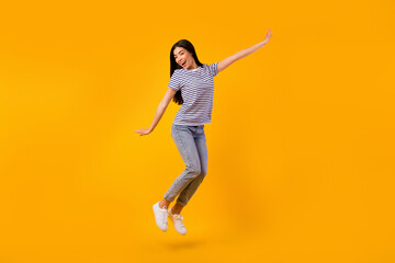 Fototapeta na wymiar Full body portrait of cheerful pretty person jumping have good mood isolated on yellow color background
