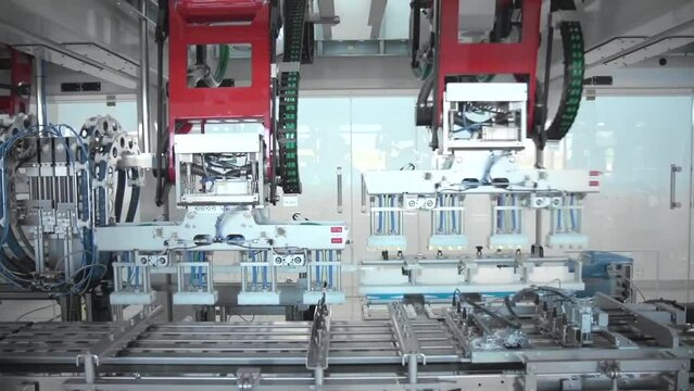 Robotic machine, robotic arm. Products in boxes. Automated plant, conveyor line. Modern plant. Machines work. 
