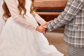 During the wedding ceremony, the bride and groom hold hands. Wedding celebration.