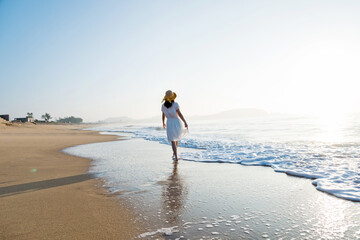 Young woman walking at the beach.