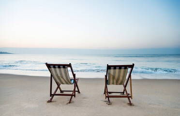Two chairs on the beach.