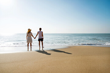 Young couple holding hand at the beach.
