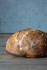 Fresh homemade sourdough bread with whole grain flour on a gray-blue background. Healthy food.