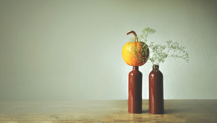 Composition of clay bottles, a sprig of Baby's Breath, a pumpkin. Monochrome light background....